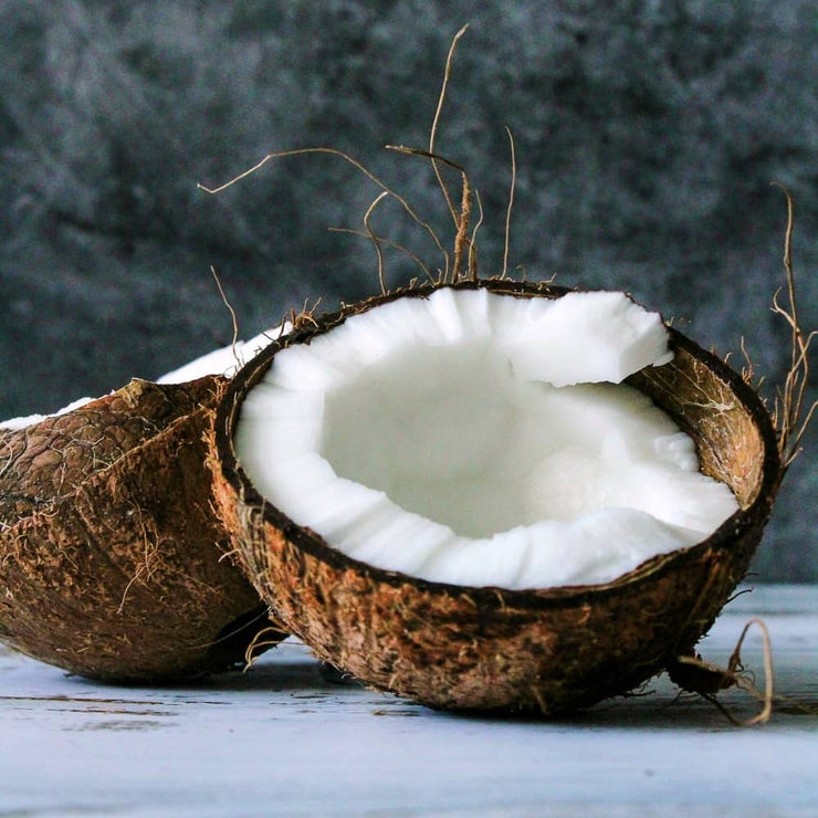 A fresh raw coconut cut in half to show the freshness of the Raw Natural Coconut Superfood for Dogs by K9 Gourmet.